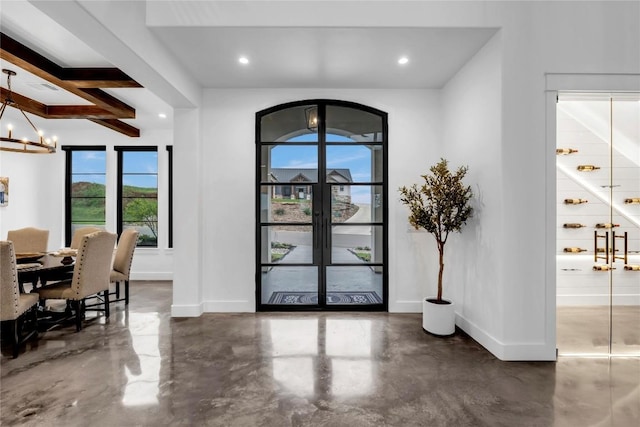 entryway with concrete flooring, recessed lighting, an inviting chandelier, and baseboards