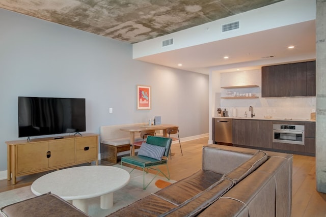 living room featuring sink and light wood-type flooring