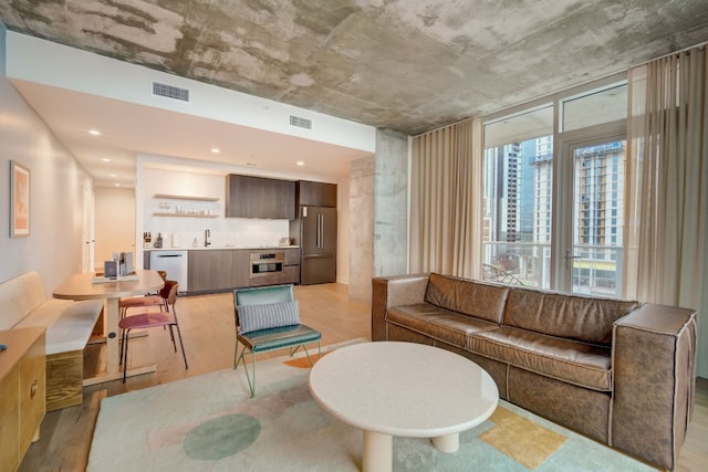 living room with sink and light hardwood / wood-style floors