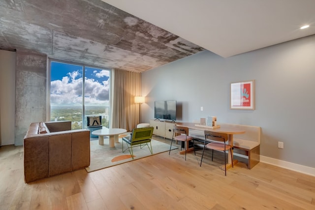 office space with floor to ceiling windows and light hardwood / wood-style floors