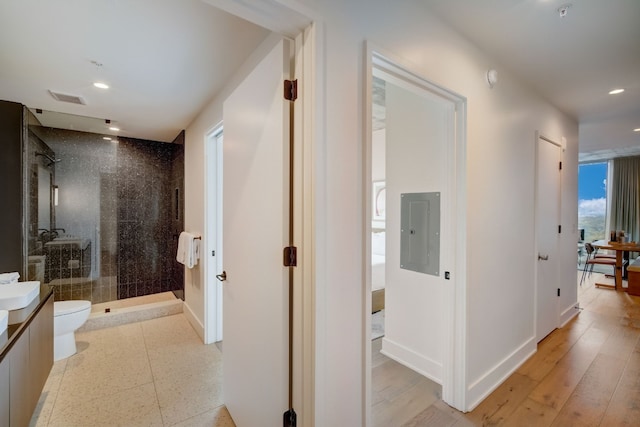 hallway featuring tile patterned floors and electric panel