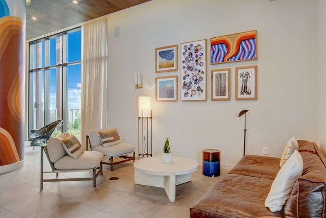 tiled living room featuring wood ceiling and a wall of windows