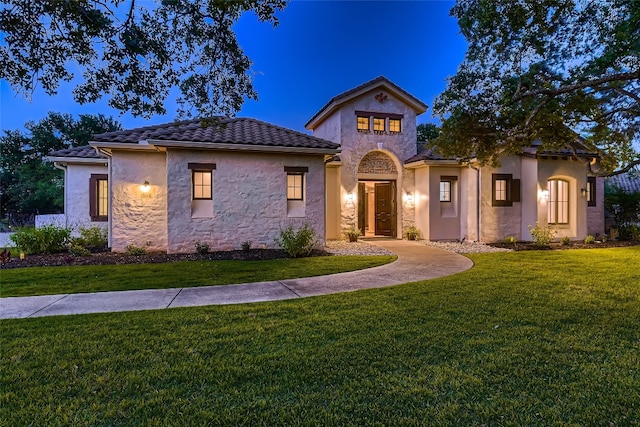 mediterranean / spanish-style home with a front lawn