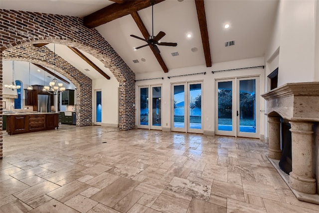 unfurnished living room featuring beamed ceiling, sink, brick wall, french doors, and high vaulted ceiling