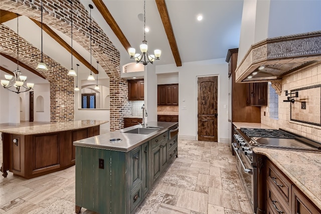 kitchen with beamed ceiling, sink, high end range, decorative light fixtures, and a spacious island