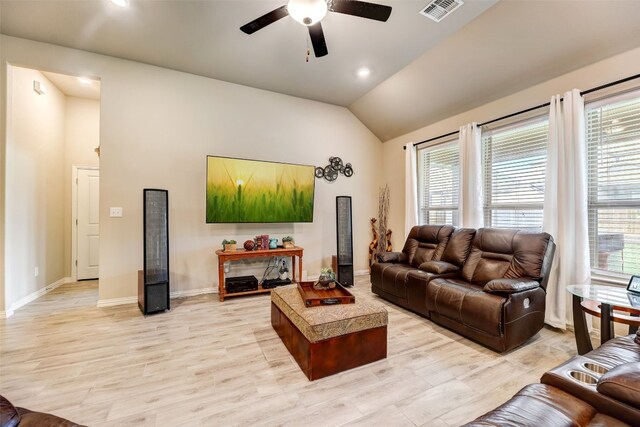 living room with a wealth of natural light, light hardwood / wood-style flooring, ceiling fan, and vaulted ceiling