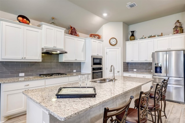 kitchen featuring white cabinets, sink, appliances with stainless steel finishes, and an island with sink