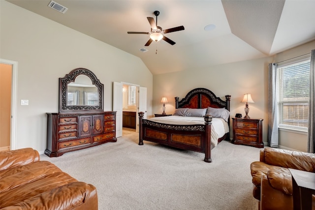 carpeted bedroom featuring a tray ceiling, ensuite bath, ceiling fan, and vaulted ceiling