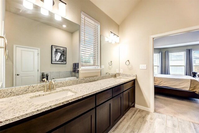 bathroom featuring vanity and lofted ceiling