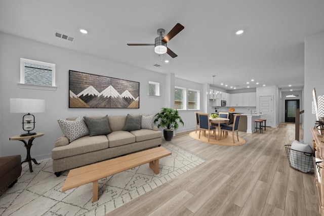 living room with light hardwood / wood-style floors and ceiling fan