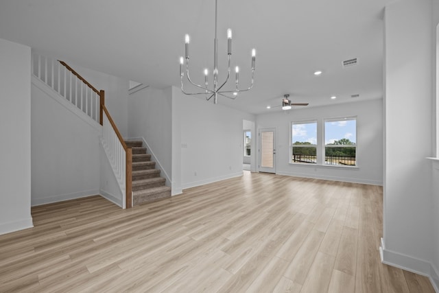 unfurnished living room featuring ceiling fan with notable chandelier and light hardwood / wood-style flooring