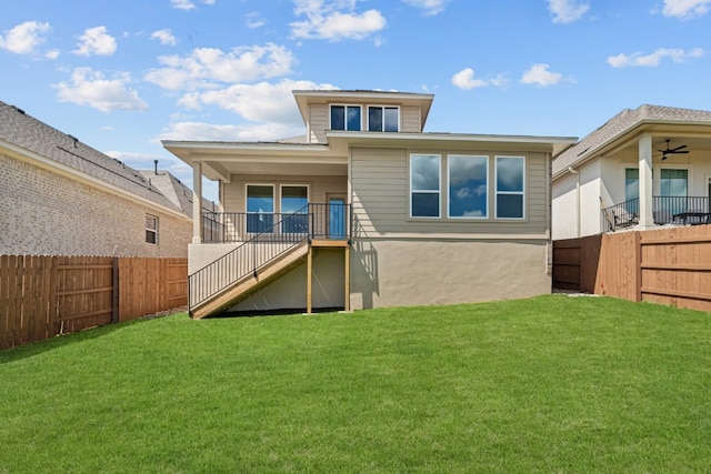 rear view of property with a yard and ceiling fan