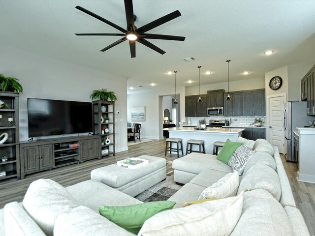 living room featuring ceiling fan and light wood-type flooring