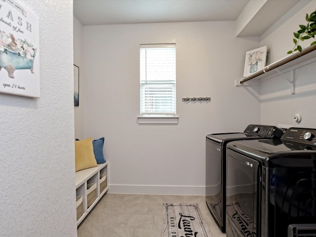 clothes washing area with independent washer and dryer and light tile flooring