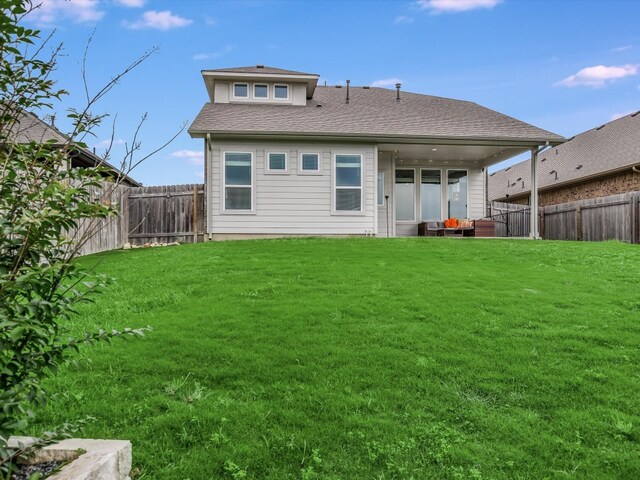 rear view of property featuring a yard