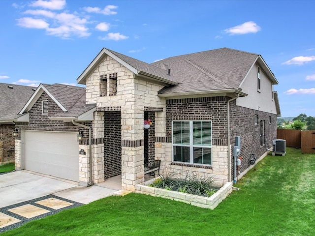 view of front of property with a garage, a front yard, and central air condition unit