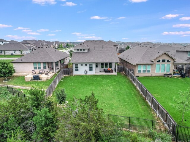 rear view of house featuring a lawn and a patio