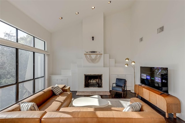 living area with visible vents, dark wood finished floors, a fireplace, high vaulted ceiling, and recessed lighting