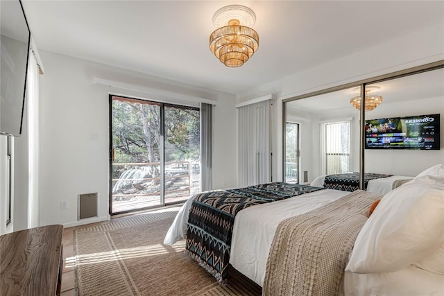 bedroom with access to exterior, baseboards, and a chandelier