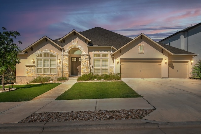 view of front of home featuring a garage and a yard