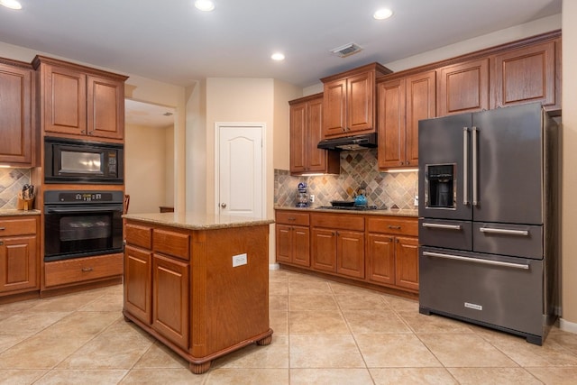 kitchen featuring decorative backsplash, a center island, light tile patterned flooring, and black appliances