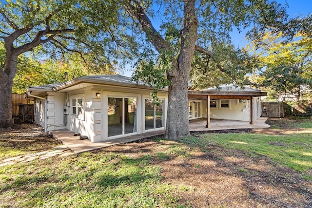 rear view of house featuring a lawn and a patio