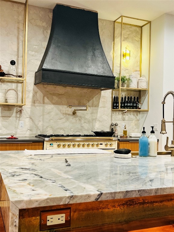 kitchen with decorative backsplash, range hood, and white gas cooktop