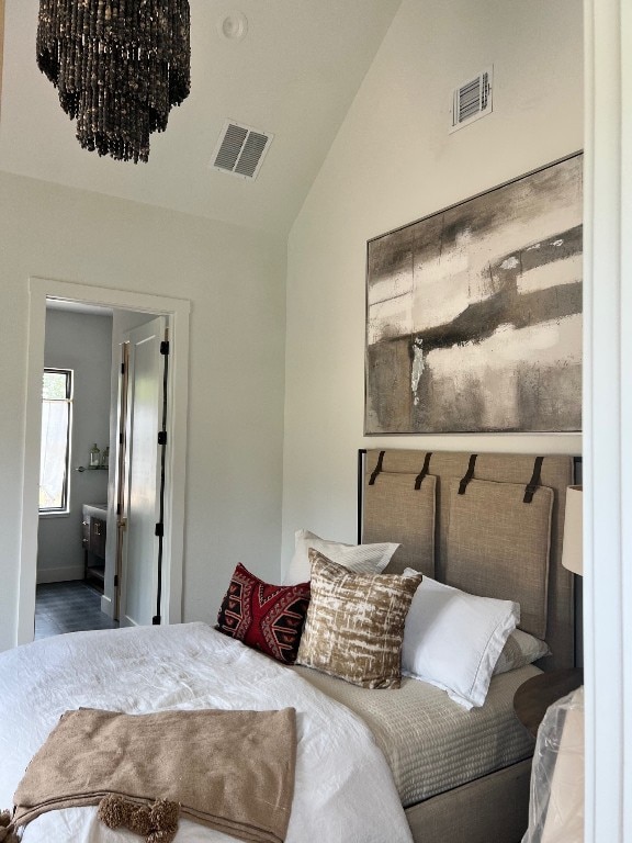 bedroom with connected bathroom and high vaulted ceiling