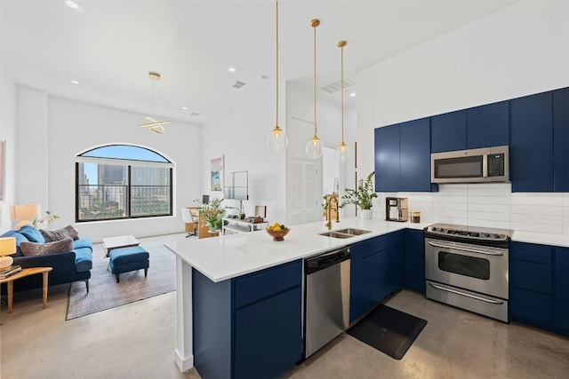 kitchen featuring decorative light fixtures, decorative backsplash, kitchen peninsula, and stainless steel appliances