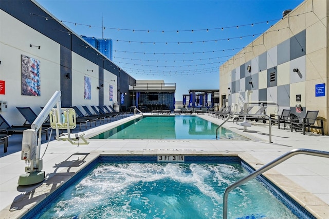 view of pool with a patio area and a hot tub