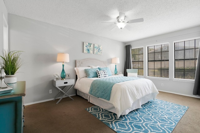 bedroom featuring ceiling fan, a textured ceiling, and dark colored carpet