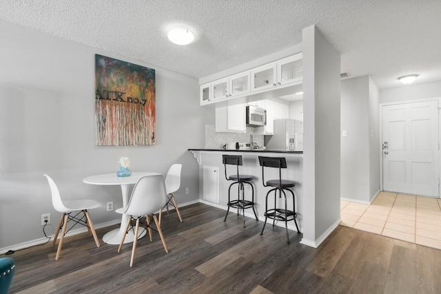 dining area featuring a textured ceiling and dark hardwood / wood-style floors