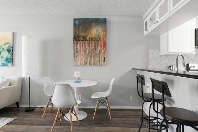 dining space featuring a textured ceiling and dark wood-type flooring