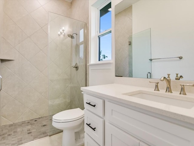 bathroom with walk in shower, vanity, and toilet