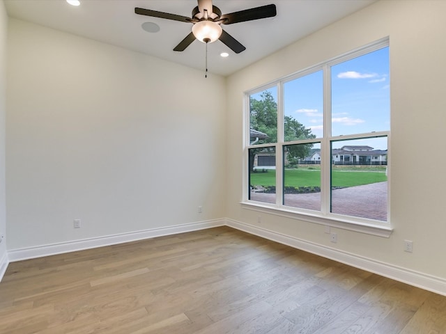 empty room featuring ceiling fan, plenty of natural light, and light hardwood / wood-style flooring