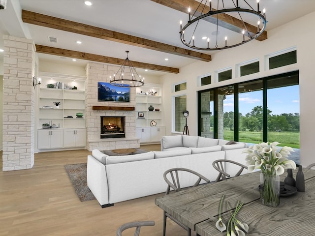 living room featuring beamed ceiling, built in shelves, light wood-type flooring, and a fireplace