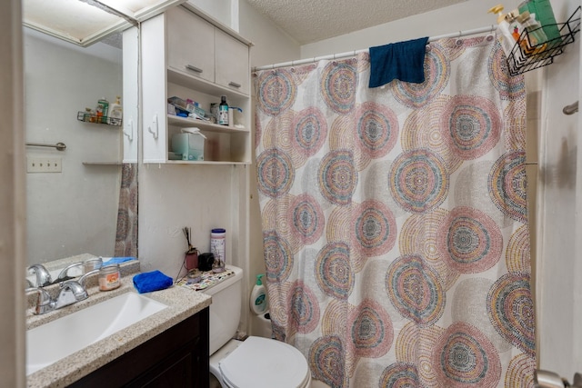 bathroom with toilet, vanity, and a textured ceiling