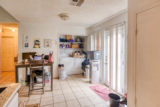 kitchen with a wealth of natural light, washer and clothes dryer, a textured ceiling, and light tile flooring