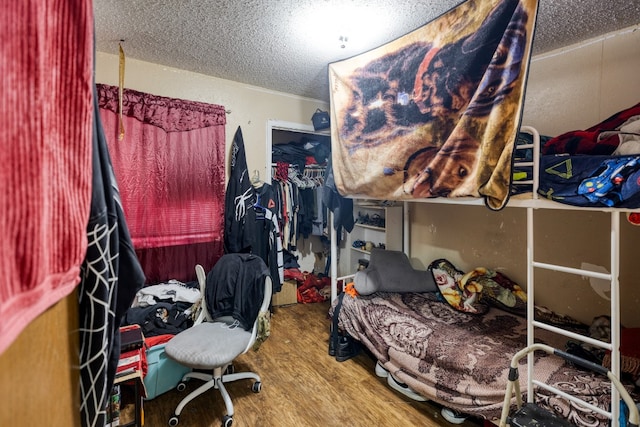 bedroom featuring hardwood / wood-style flooring and a textured ceiling