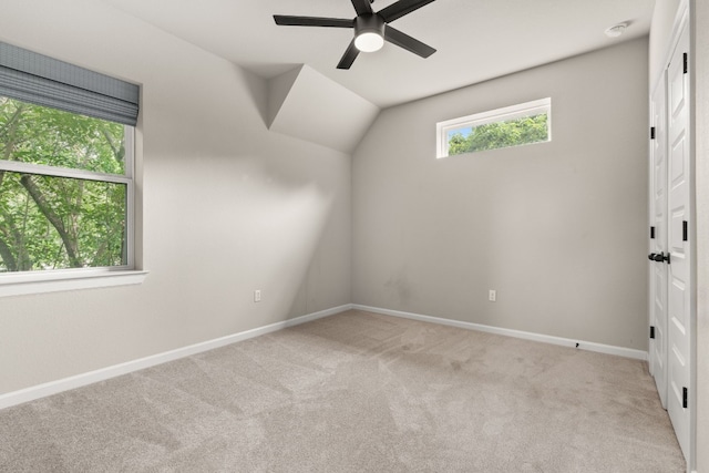 unfurnished bedroom with light carpet, ceiling fan, and vaulted ceiling