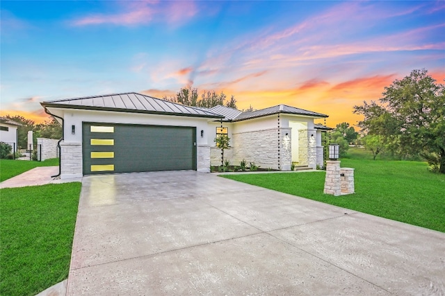 prairie-style home featuring a garage and a yard