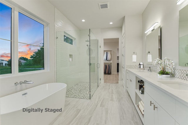 bathroom featuring double vanity, tile flooring, and plus walk in shower