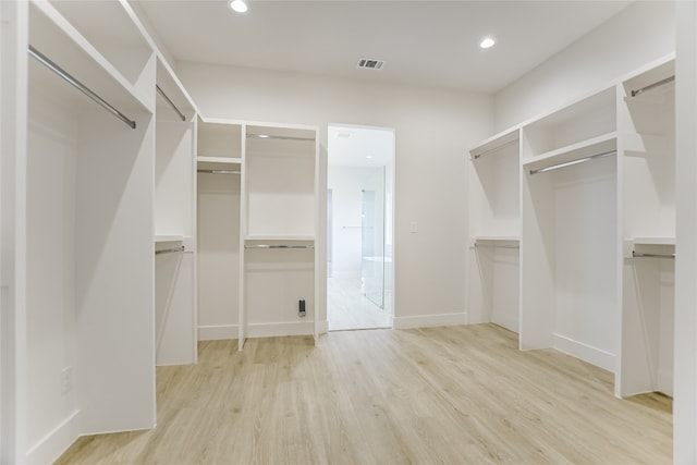 walk in closet with light wood-type flooring