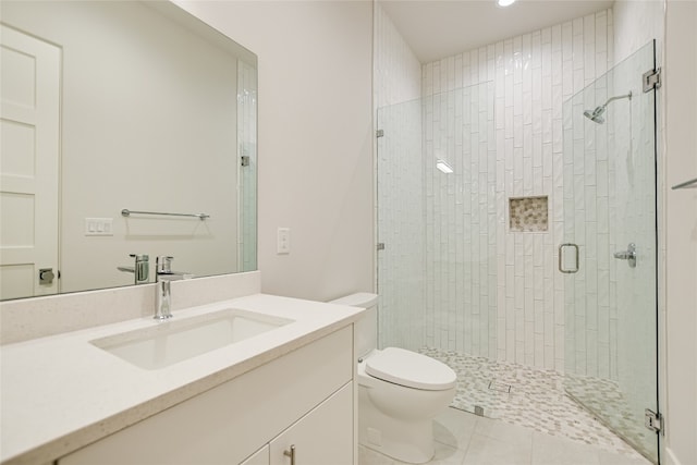 bathroom featuring tile floors, large vanity, toilet, and walk in shower