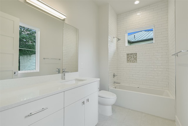 full bathroom featuring tile floors, vanity with extensive cabinet space, toilet, and tiled shower / bath combo