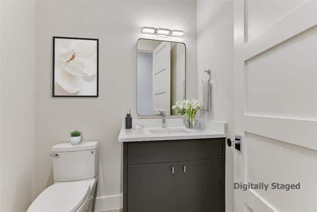 bathroom featuring toilet and vanity with extensive cabinet space