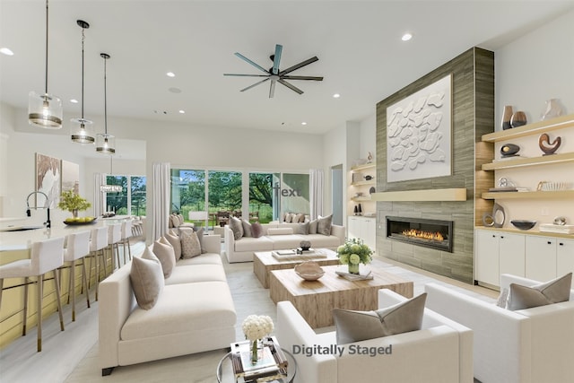 living room featuring tile walls, a fireplace, built in features, ceiling fan, and sink