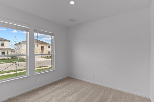 spare room featuring light carpet