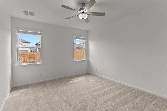 unfurnished room with light colored carpet and ceiling fan