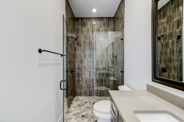 bathroom featuring toilet, tile patterned flooring, walk in shower, and vanity